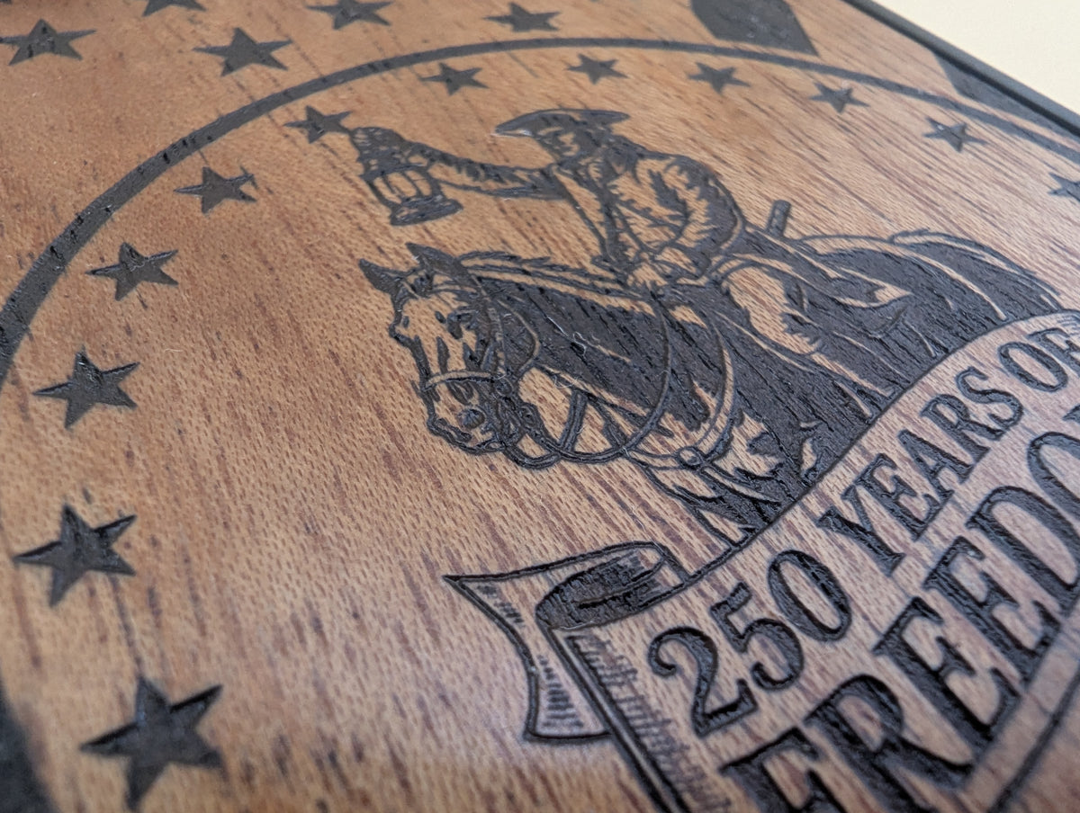 Wooden phone case with engraved design of a paul revere on horseback and text '250 Years of Freedom'.